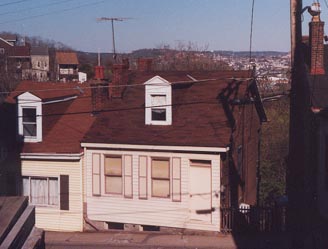 Houses cling precariously to the side of the hill